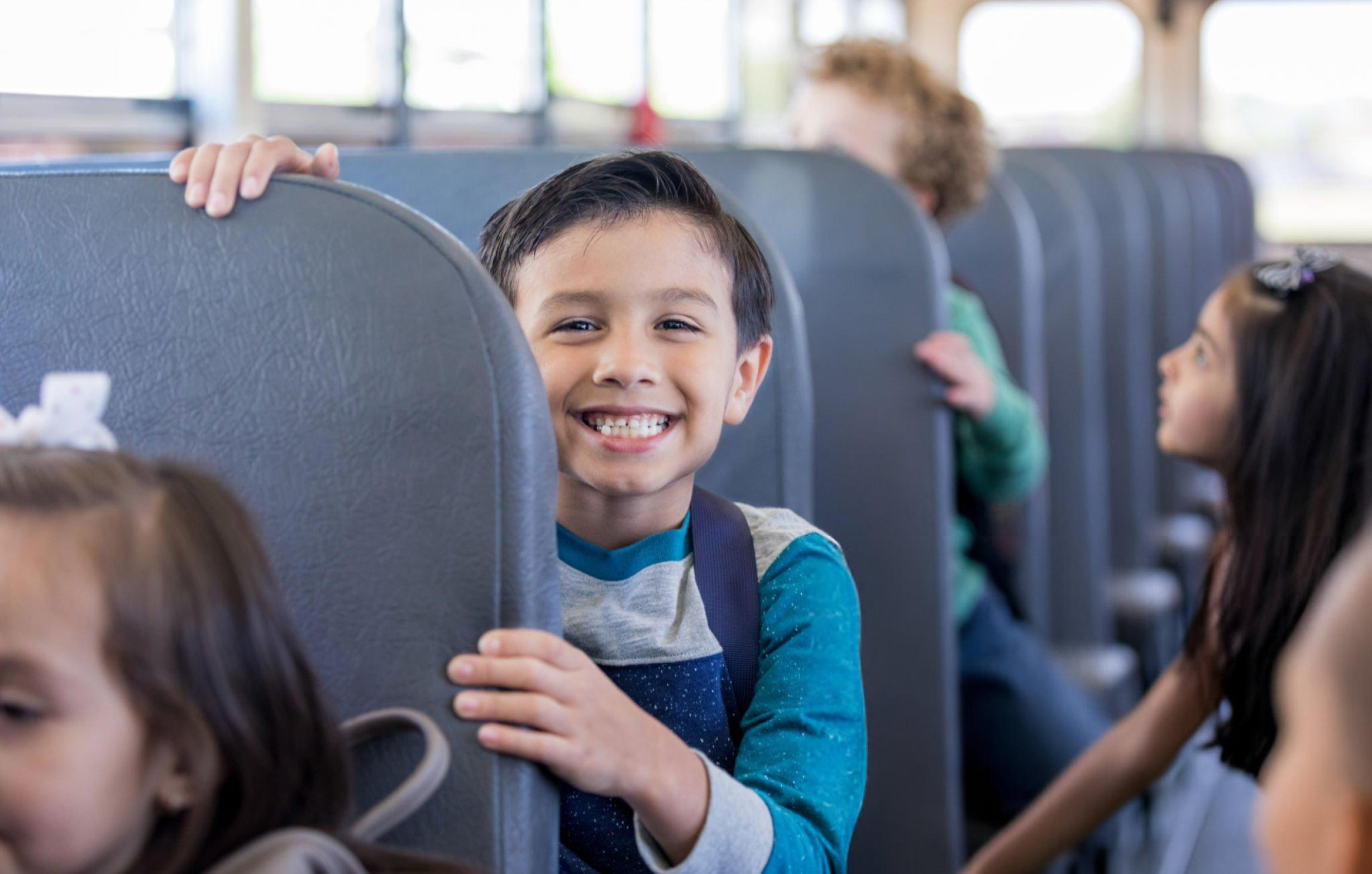 Jeune garçon souriant dans un transport en commun lors d'un voyage éducatif